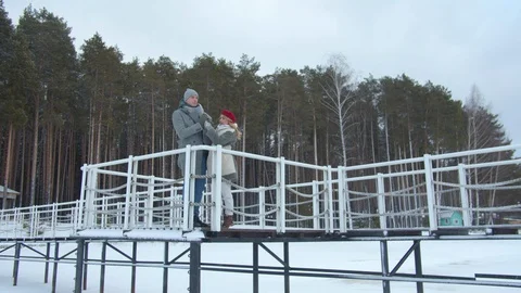 A couple stands at the railing of the pier and flirts Stock Footage 129099778