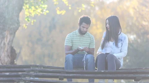 Couple starting to listen to music on smartphone, sharing earphones Stock Footage 59555766