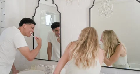 Couple starting morning routine brushing teeth with toothbrushes at bathroom Stock Footage 341242286