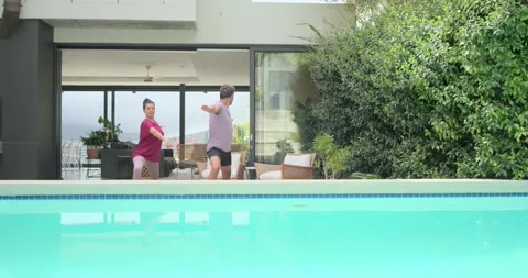Couple stepping through sliding glass, moving onto patio and practicing Stock Footage 337625230