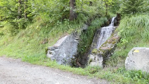 Couple stops to watch a small waterfall in the mountains Stock Footage 93803501