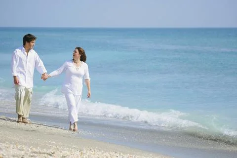 Couple Strolling On A Beach Stock Photos