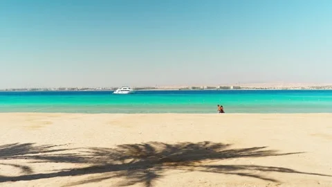 A couple strolls along the sandy beach of the Red Sea with turquoise water. Stock-Footage 341916447