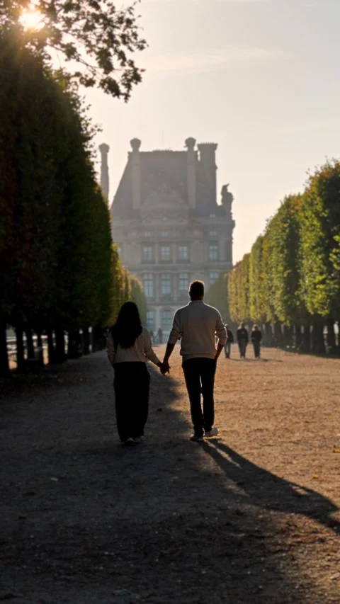 Couple strolls hand in hand through the enchanting Tuileries Garden in Paris Stock-Footage 347997705