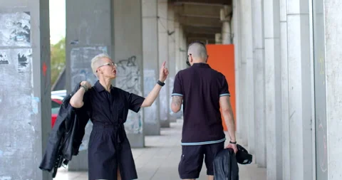 Couple strolls through city. Active communication suggests dynamic interaction Stock Footage 255809579