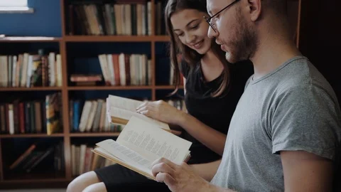 Couple of students study with books sitting in modern stylish room with Stock Footage 98559526