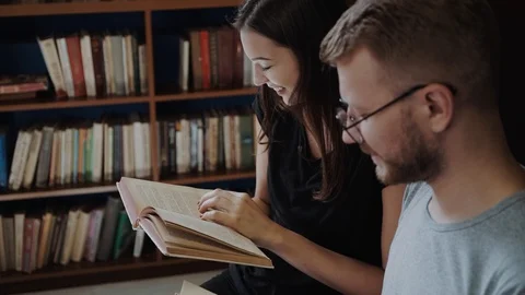 Couple of students study with books sitting in modern stylish room with Stock Footage 98875228