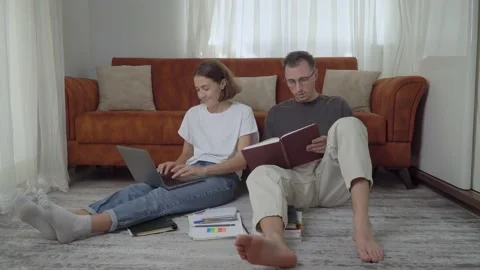 A couple of students study at home reading and typing on a laptop, home Stock Footage 204805220