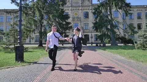Couple of Students Young Man is Twisting a Woman in Mantle With Diploma Girl Stock Footage 64813624
