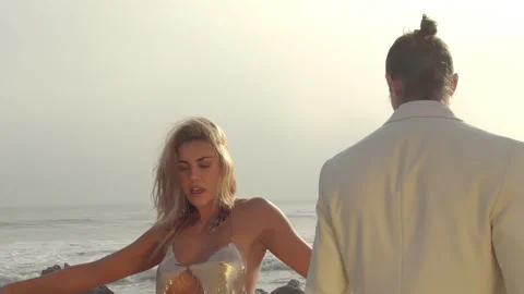 A couple of stylish lovers on the shore posing by the ocean on Malibu Stock Footage 168188779