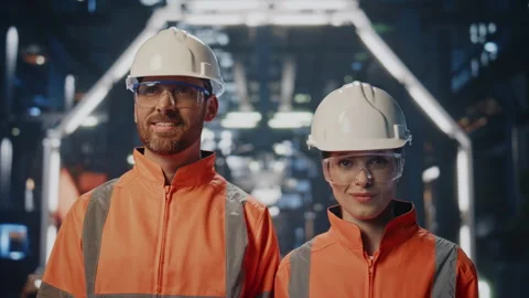 Couple successful factory engineer posing in modern facility in helmets closeup. Stock Footage 254407642