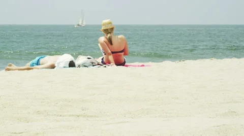 Couple sunbathing on the beach 스톡 동영상 1079745