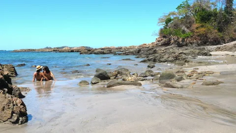 Couple sunbathing on a virgin tropical beach Stock Footage 105582322