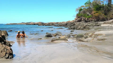 Couple sunbathing on a virgin tropical beach Stock Footage 105584925