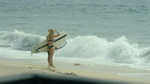 Couple with surfboards waiting on beach Stock Footage 106325697
