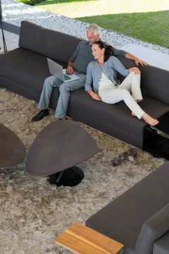 Couple surfing the web on sofa Stock Photos