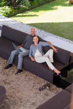 Couple surfing the web on sofa Stock Photos