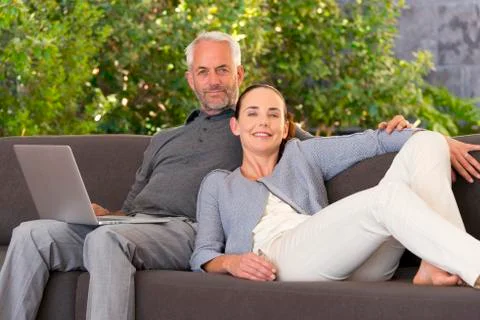 Couple surfing the web on sofa Stock Photos