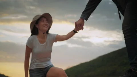 Couple survivalists pulling hands up the hill en route to destination Stock Footage 161053615