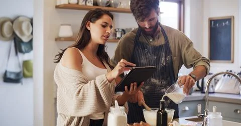 Couple, tablet and baking in kitchen with milk, online tutorial and instructions Fotos Stock