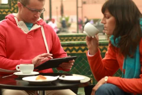 Couple with tablet computer in cafe by city street, steadicam shot 스톡 동영상 10842226
