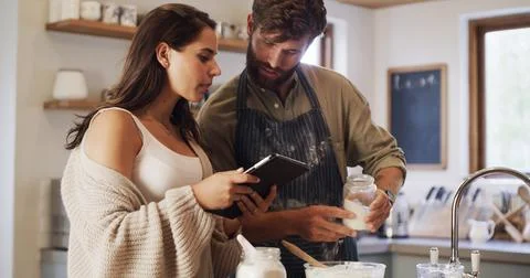 Couple, tablet or baking in kitchen with online tutorial, help or instructions Fotos Stock