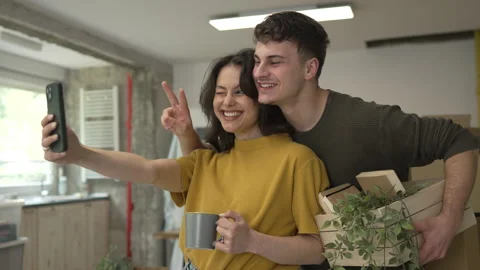 Couple take a self portrait and have fun during the move in new home Stock Footage 320645236