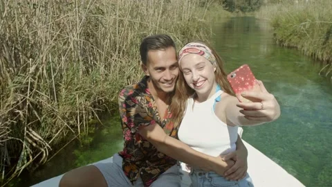 Couple take a selfie while enjoying the peace and scenery on the boat tour. Stock Footage 144328605