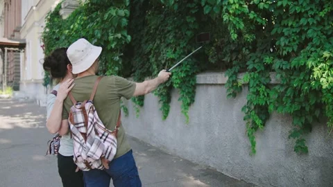 Couple takes a selfie while exploring a historic site surrounded by greenery on Stock Footage 301105530