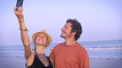 Couple takes a selfie while standing on the beach Stock Footage 57634643