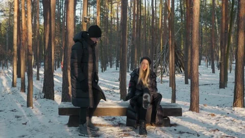 A couple taking a break on a bench during a family walk in a winter forest. 스톡 동영상 311955639