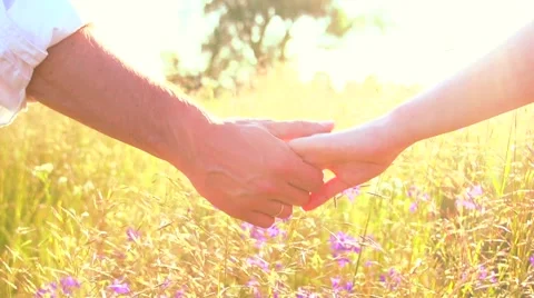 Couple taking hands and running together on summer meadow field Stock Footage 67358843