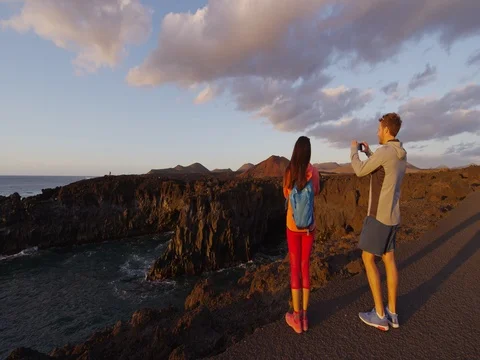 Couple taking photo using mobile phone in volcano mountains of Lanzarote Video stock 84009516