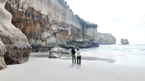 A Couple Taking a Picture on a Beach Stock Footage 328438664