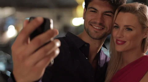 Couple taking a self portrait on cell phone at night. Stock Footage 43634229