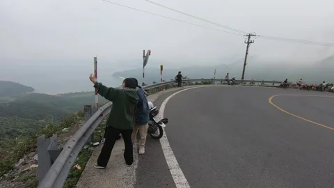 A couple is taking a selfie on a cloudy mountain pass with a sea view Stock-Footage 219677302