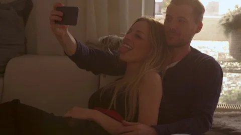 Couple taking a selfie on a couch   Stock Footage 111256182