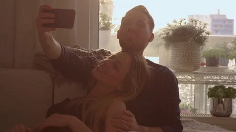 Couple taking a selfie on a couch   Stock Footage 111256253