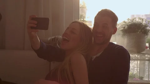 Couple taking a selfie on a couch   Stock Footage 111256419