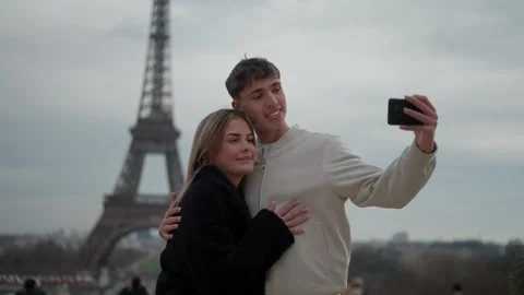 Couple taking selfie with Eiffel Tower in Paris France Young lovers embracing Stock Footage 325269998