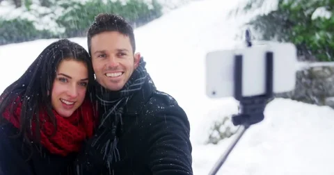 Couple taking selfie on mobile phone during winter Stock Footage