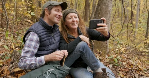 Couple taking a selfie photo while resting during a hike during the autumn Video stock 112019870