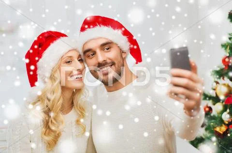 Couple taking selfie with smartphone at christmas Stock Photos