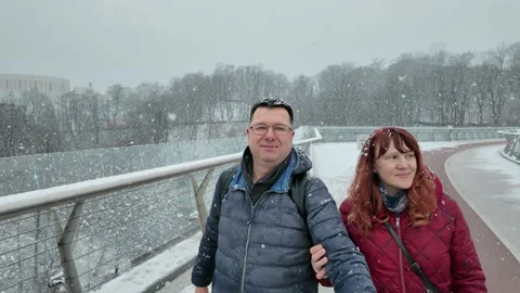 Couple taking selfie video on a snowy bridge in Kyiv Stock Footage 311982997