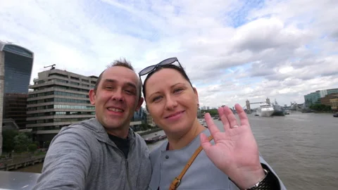 Couple taking selfie with view of Thames river in London in 4k slow motion 60fps Stock Footage 109427015