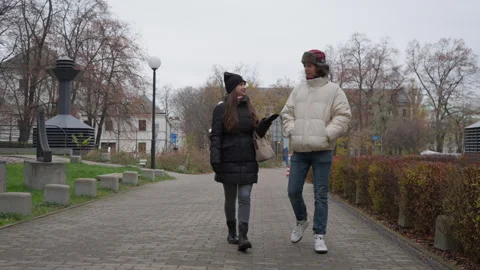 A couple taking a slow, romantic stroll through a quiet park in autumn Stock Footage 311461558