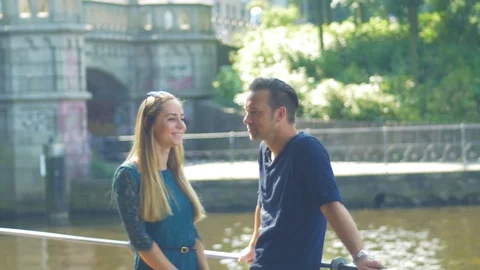 A couple talk relaxed on the riverside Stock Footage 90563632