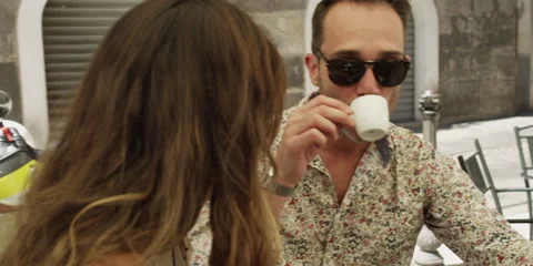 Couple talking and having coffee at outdoor cafe Stock Footage 58860904