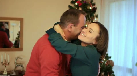 Couple talking and hugging in front of christmas tree Stock Footage 10741841