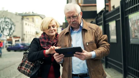 Couple talking and using tablet walking in the city Stock Footage 65443708